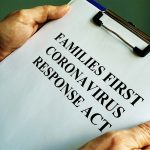 a clipboard with a printout of the Families First Coronavirus Response Act